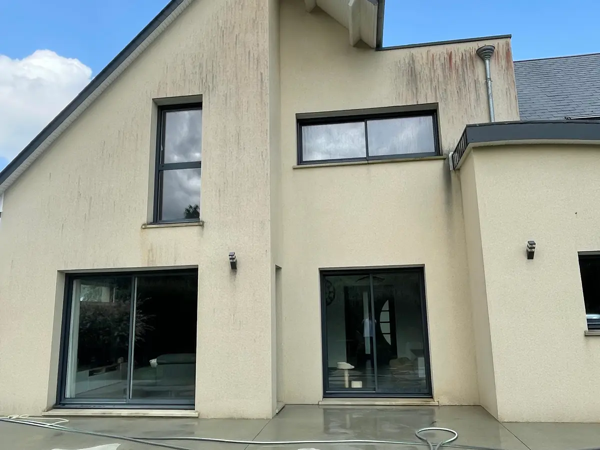 Avant nettoyage de façade à Courseulles-sur-Mer par Normandie Nettoyage — nettoyage façade maison moderne enduit crème grandes baies vitrées – algues rouges Calvados (14470)