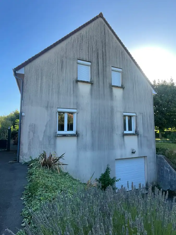 Avant nettoyage de façade à Lisieux par Normandie Nettoyage — façade enduit projeté avec coulures noires et mousse Calvados (14100)
