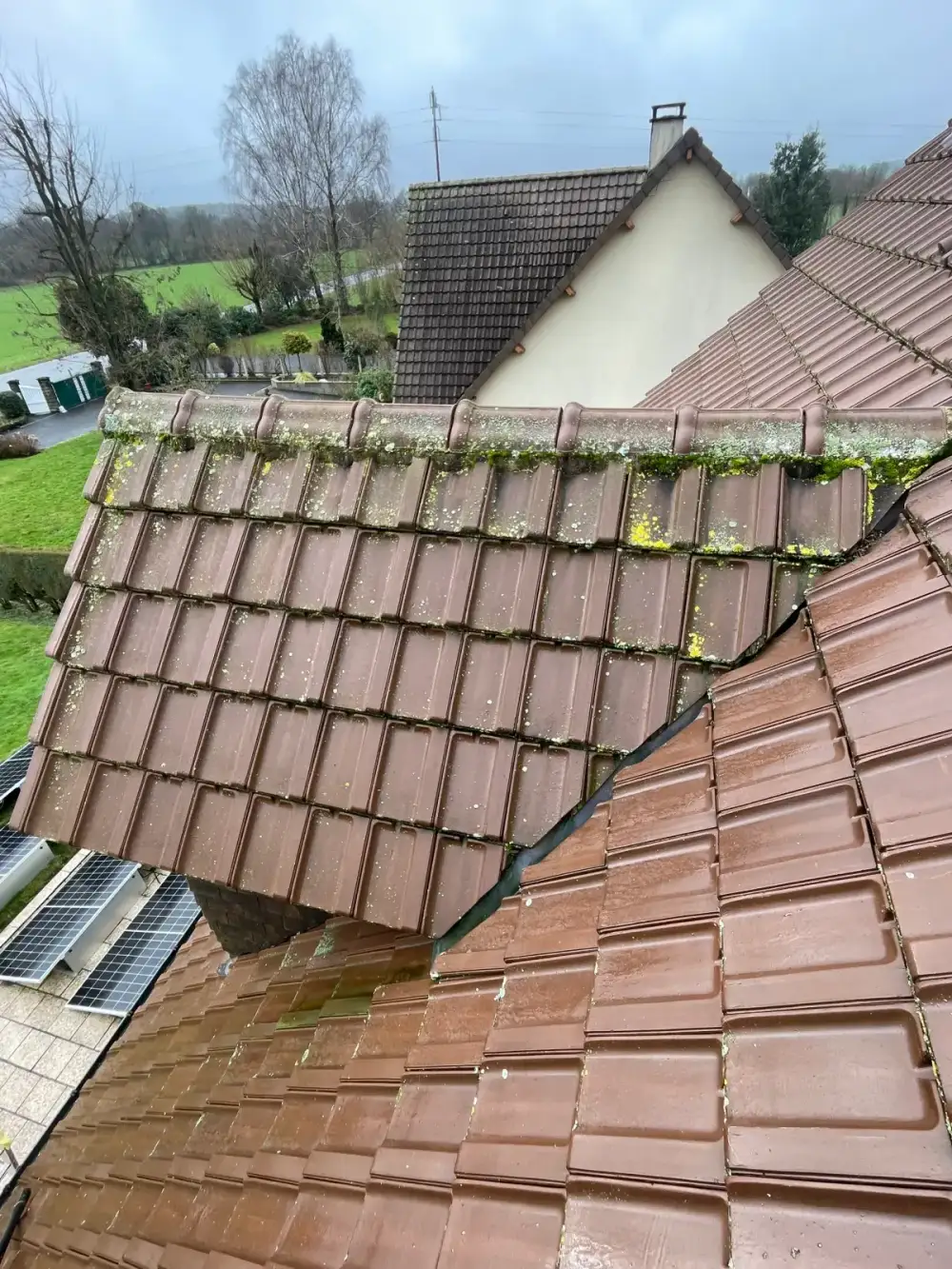 Avant démoussage de toiture à Bayeux par Normandie Nettoyage — démoussage toiture tuiles mécaniques brunes – mousse et lichen sur faîtage et noues Calvados (14400)